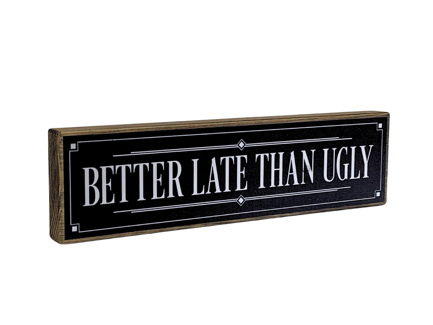 Decorative sign with 'Better Late Than Ugly' text on a black background