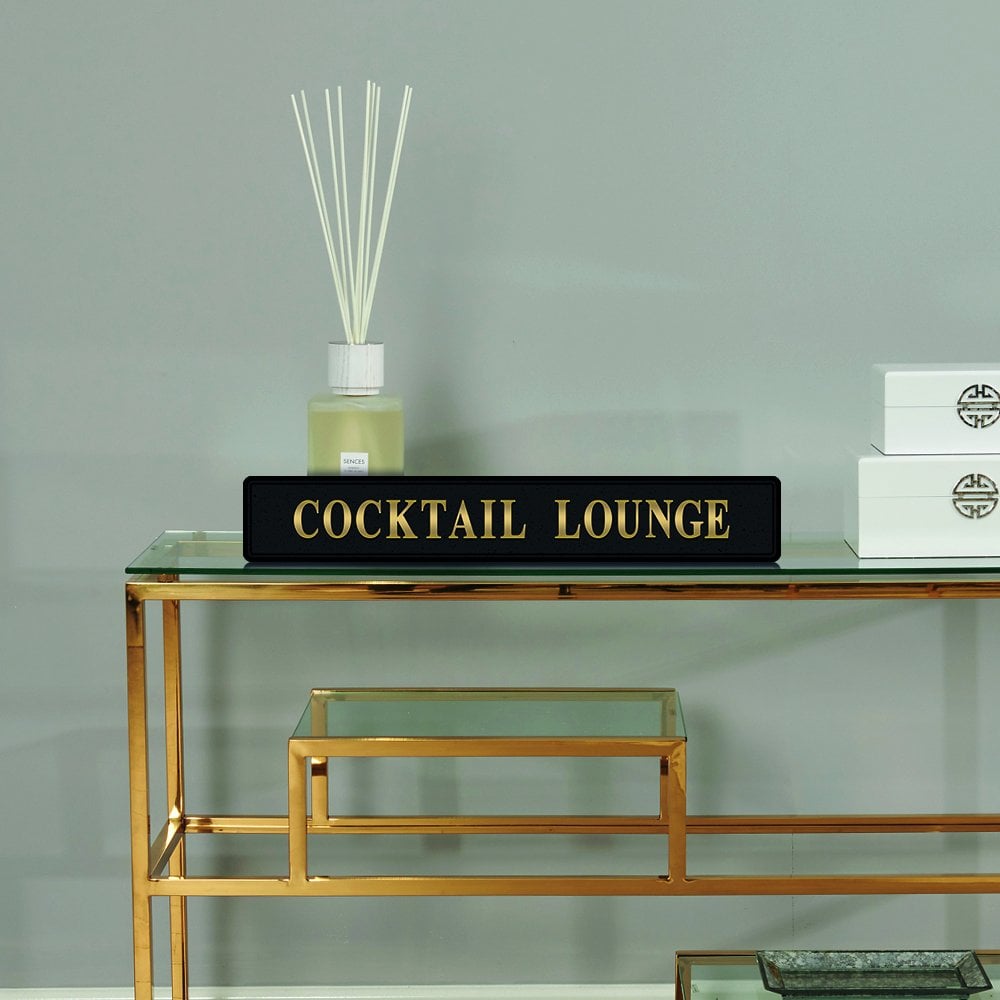 Black and gold foiled street sign with 'Cocktail Lounge' wording