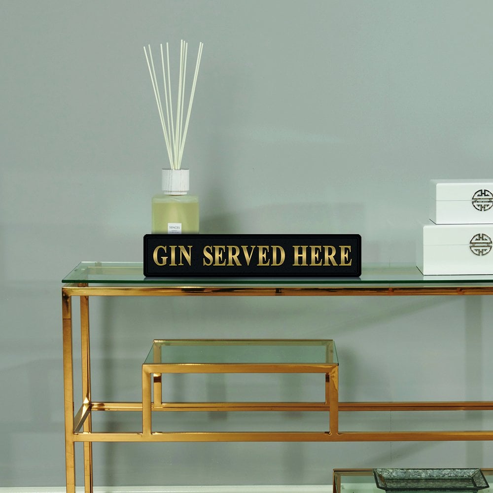 Black and gold foiled street sign with 'Gin served here' wording