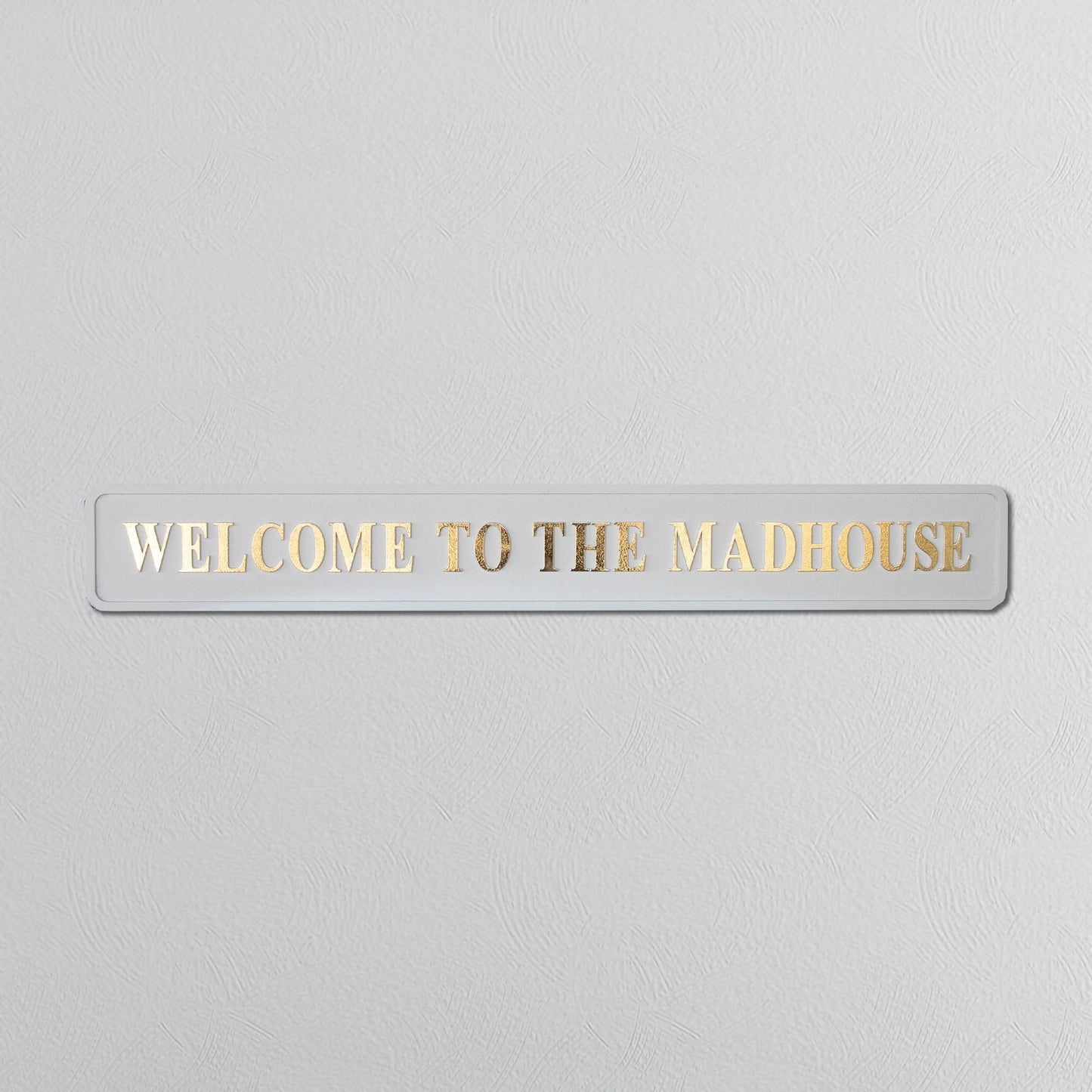 Cream and gold foiled street sign with "welcome to the madhouse" wording