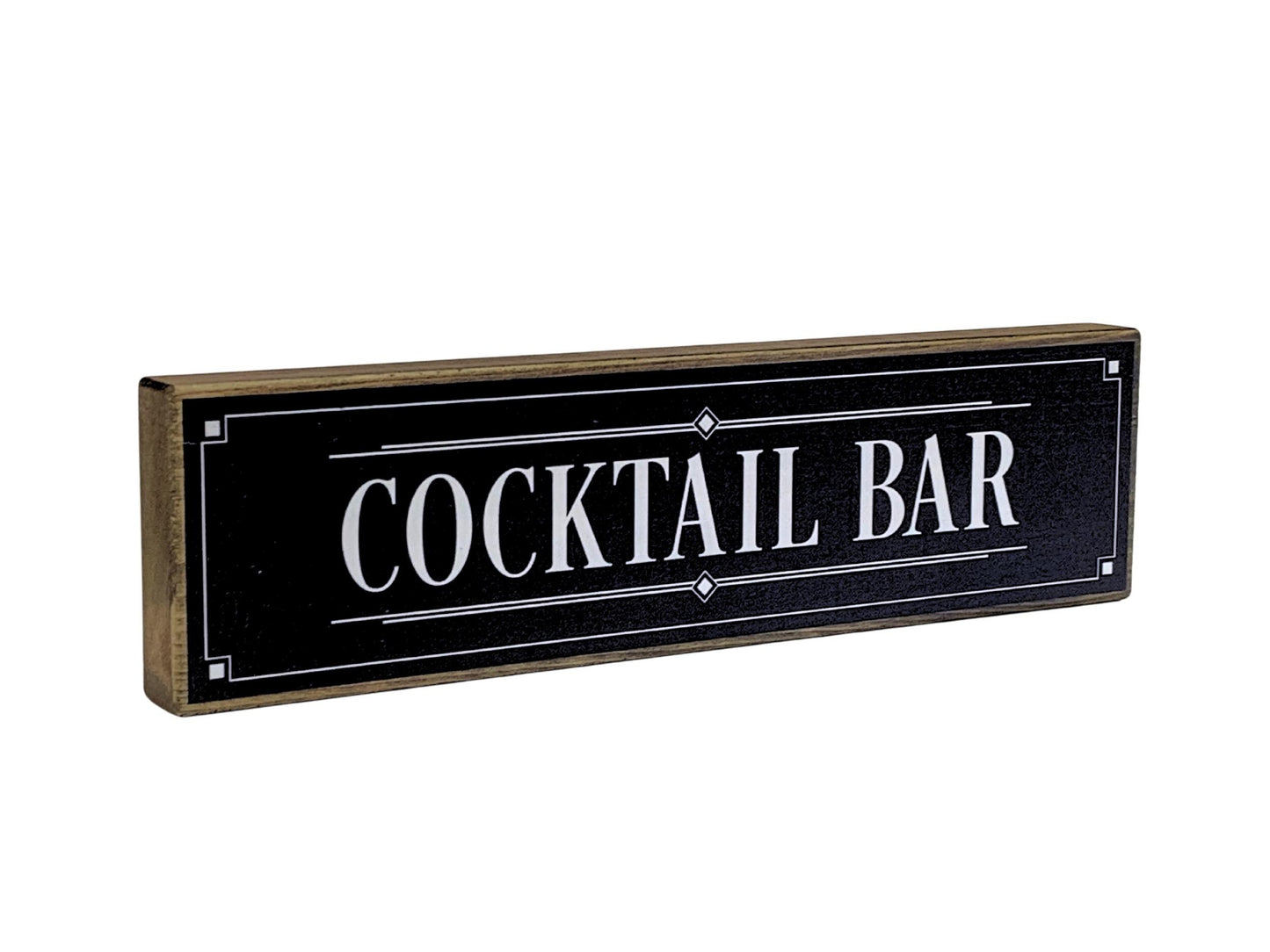 Decorative sign with 'COCKTAIL BAR' text on a black background with wooden border.