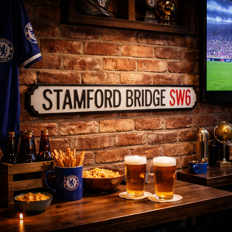 street sign with Stamford Bridge lettering mounted on a brick wall surrounded by football merch