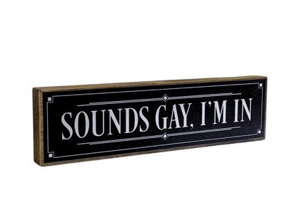 Black sign with white text 'SOUNDS GAY, I'M IN' on a white background