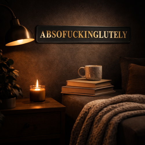 Black street sign with gold foiled lettering reading 'ABSOFUCKINGLUTELY' in a cosy setting