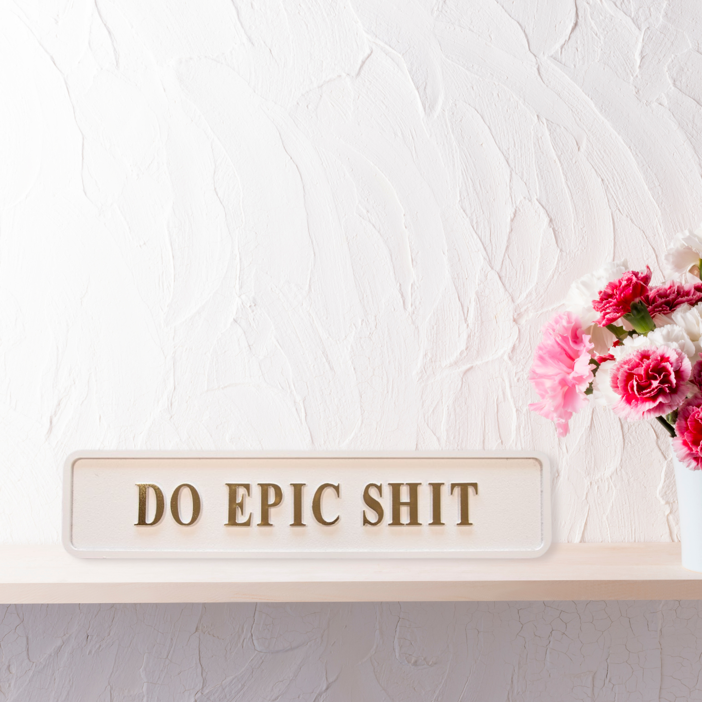 Cream and gold foiled street sign with "do epic shit" lettering