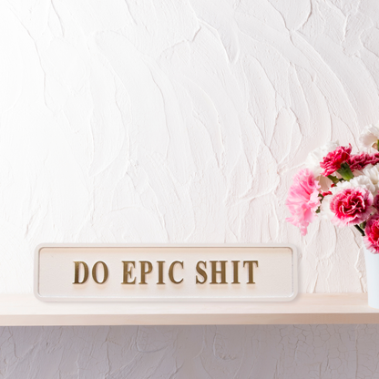 Cream and gold foiled street sign with "do epic shit" lettering