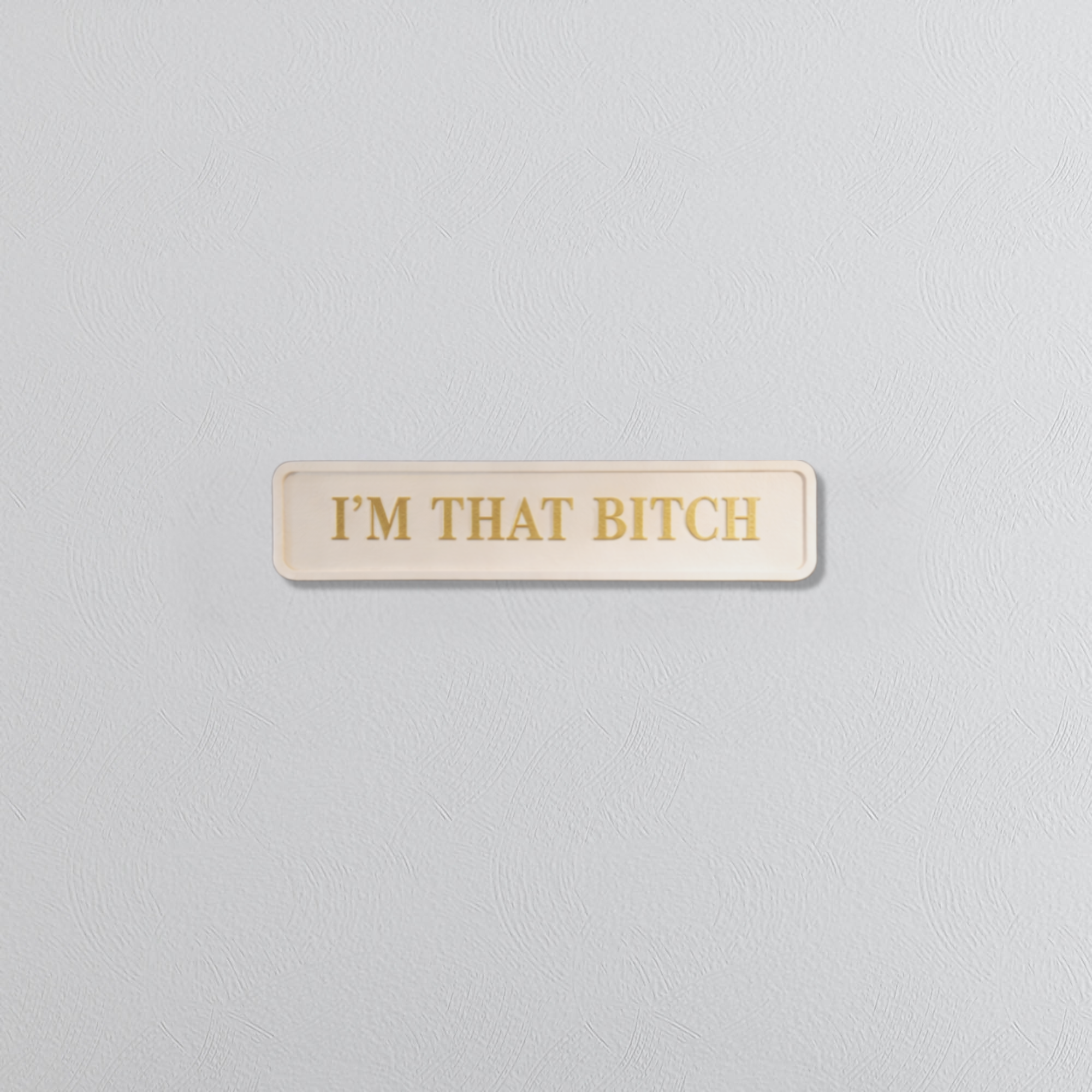 Rectangular sign with 'I'M THAT BITCH' in gold text on a light gray background