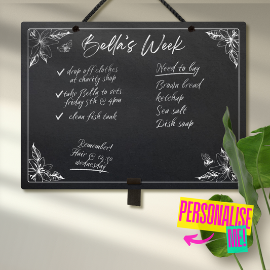 Large landscape chalkboard hanging with black rope and an adjustable pen holder at the bottom. Featuring sketchy floral illustrations framing a mostly empty space with 'Bella's Week' at the top in cursive font. A colourful sign reads 'Personalise me' whilst pointing towards the product.