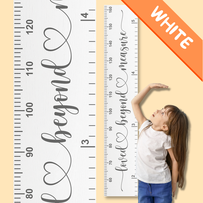 White wooden growth chart with measurement scale and 'loved beyond measure' in cursive printed up the middle, and child reaching for it, against a beige background.