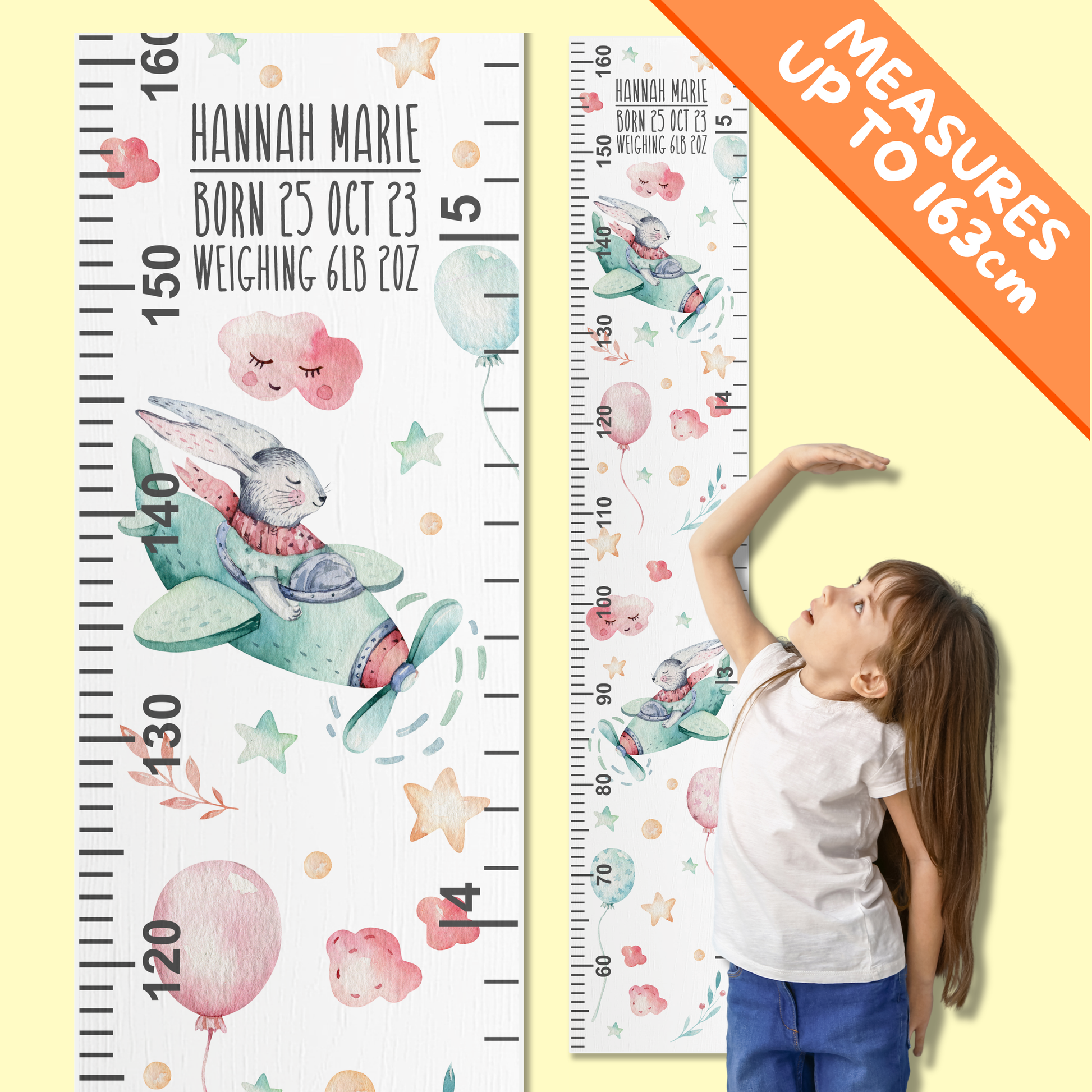 Children's growth charts with watercolour bunnies flying a plane in the clouds. A little girl is demonstrating how to use it by standing in front