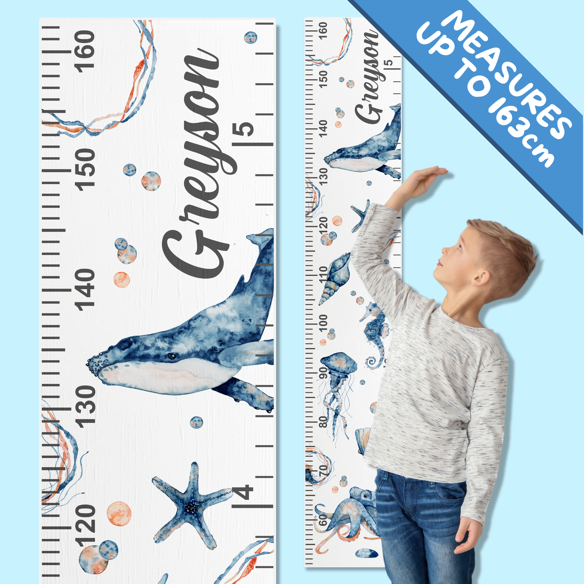 Child standing next to a under the sea themed growth chart with personalised dname printed on it.
