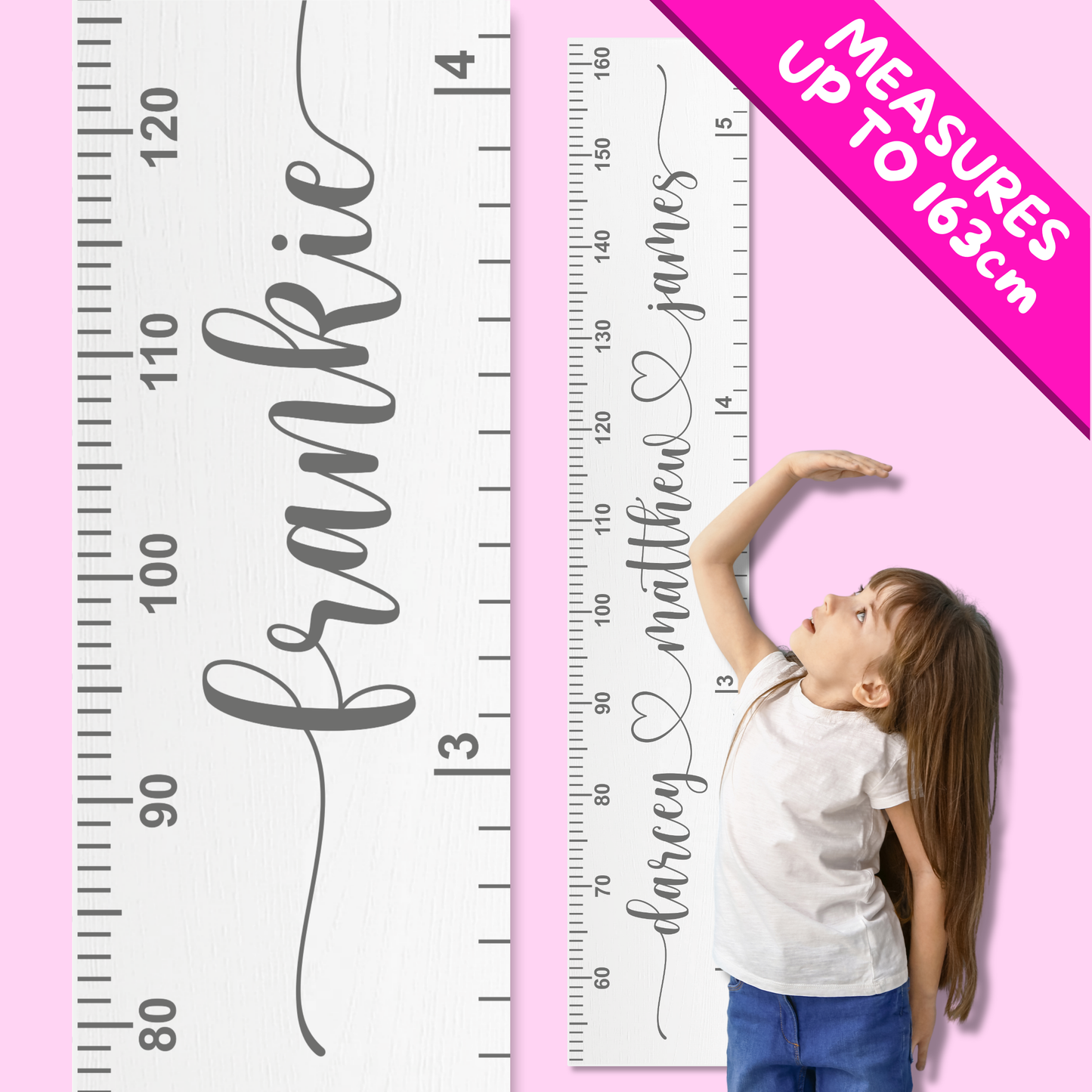 Child standing next to a personalised growth chart with names on a pink background