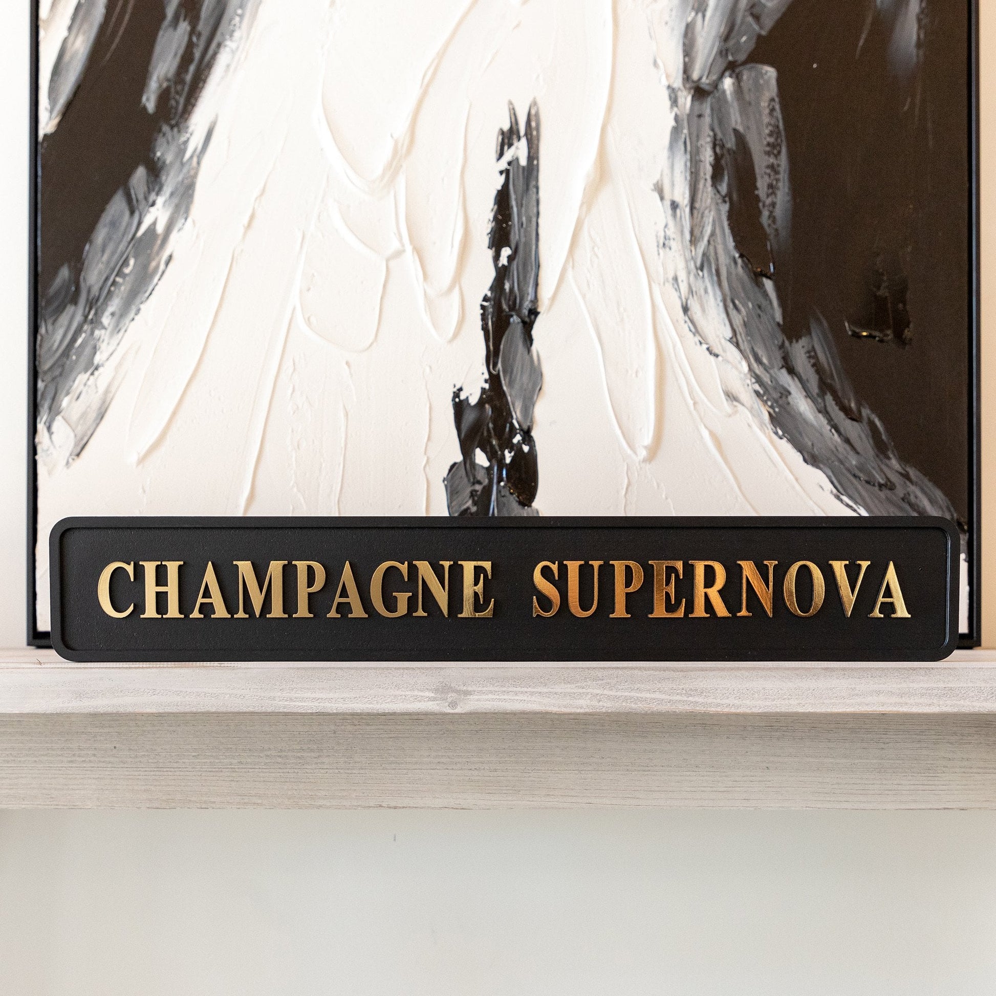 Black and gold foiled street sign with 'Champagne Supernova' wording.