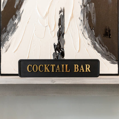 Black and gold foiled street sign with 'Cocktail bar' wording