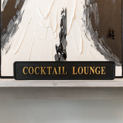 Black and gold foiled street sign with 'Cocktail Lounge' wording