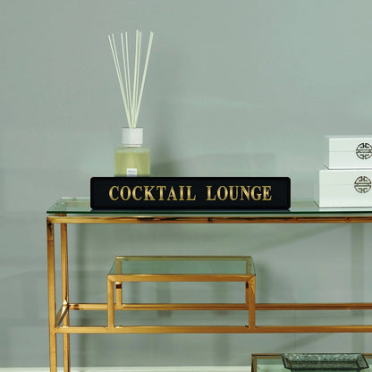 Black and gold foiled street sign with 'Cocktail Lounge' wording