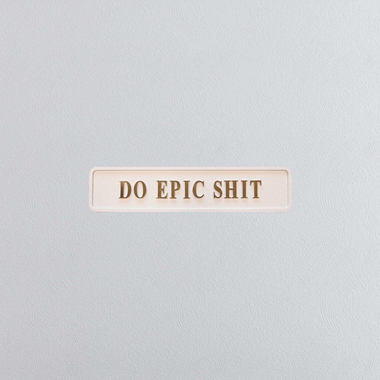 Cream and gold foiled street sign with "do epic shit" lettering