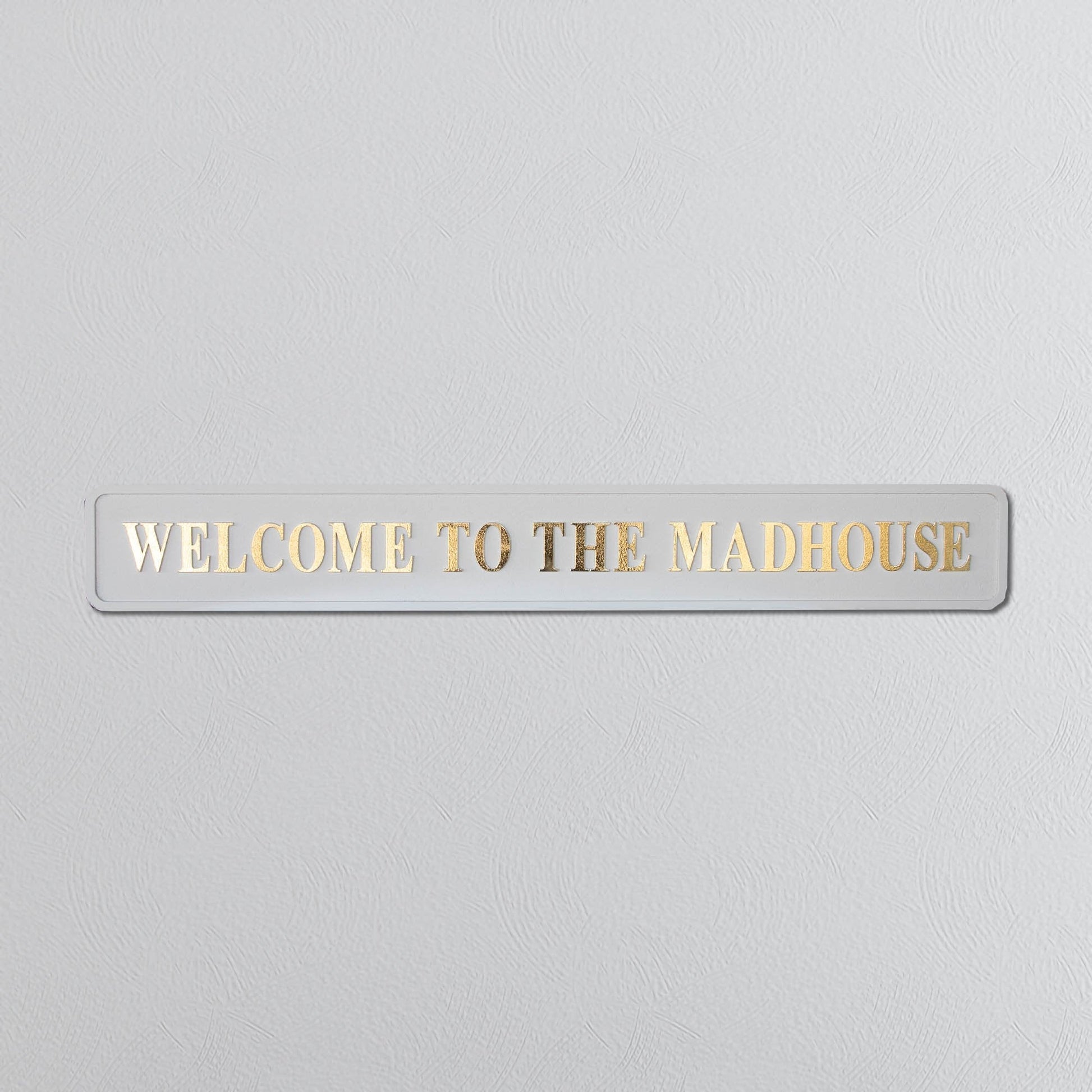 Cream and gold foiled street sign with "welcome to the madhouse" wording 