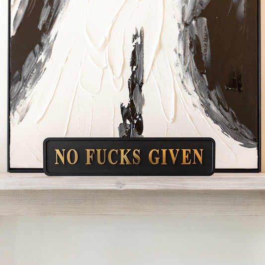 Black and gold foiled street sign with 'no fucks given' wording