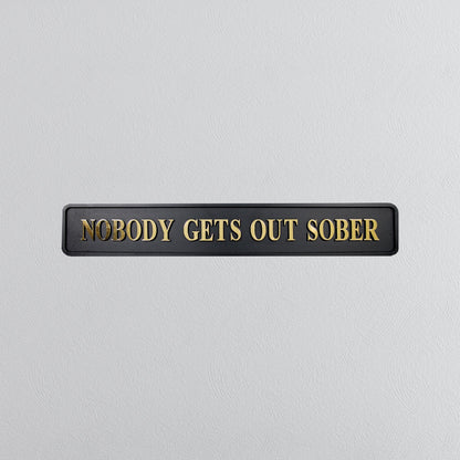 Black and gold foiled street sign with "nobody gets out sober" lettering