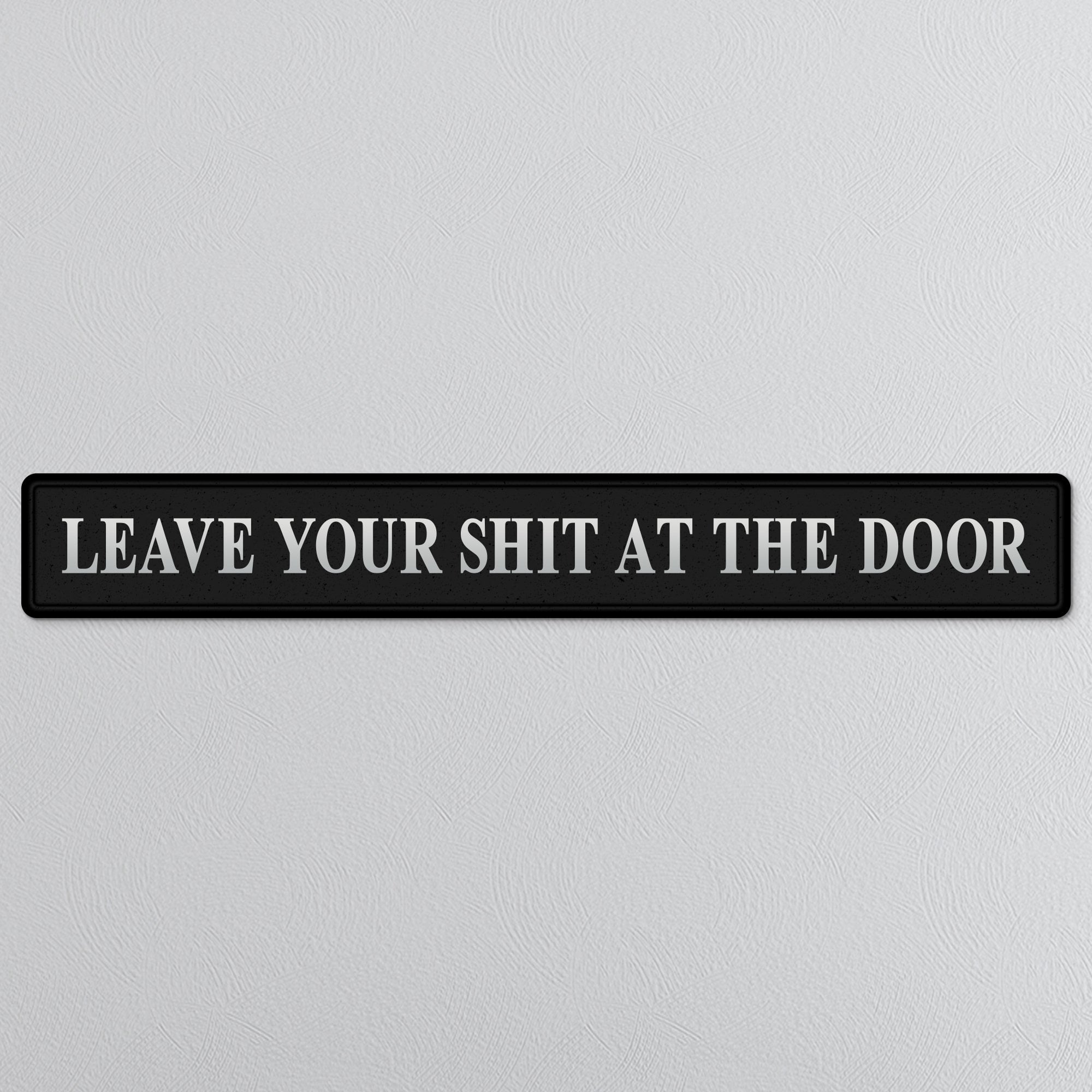 Black decorative sign with LEAVE YOUR SHIT AT THE DOOR in silver text 