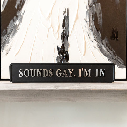 Black and silver foiled street sign with 'Sounds gay, i'm in' wording