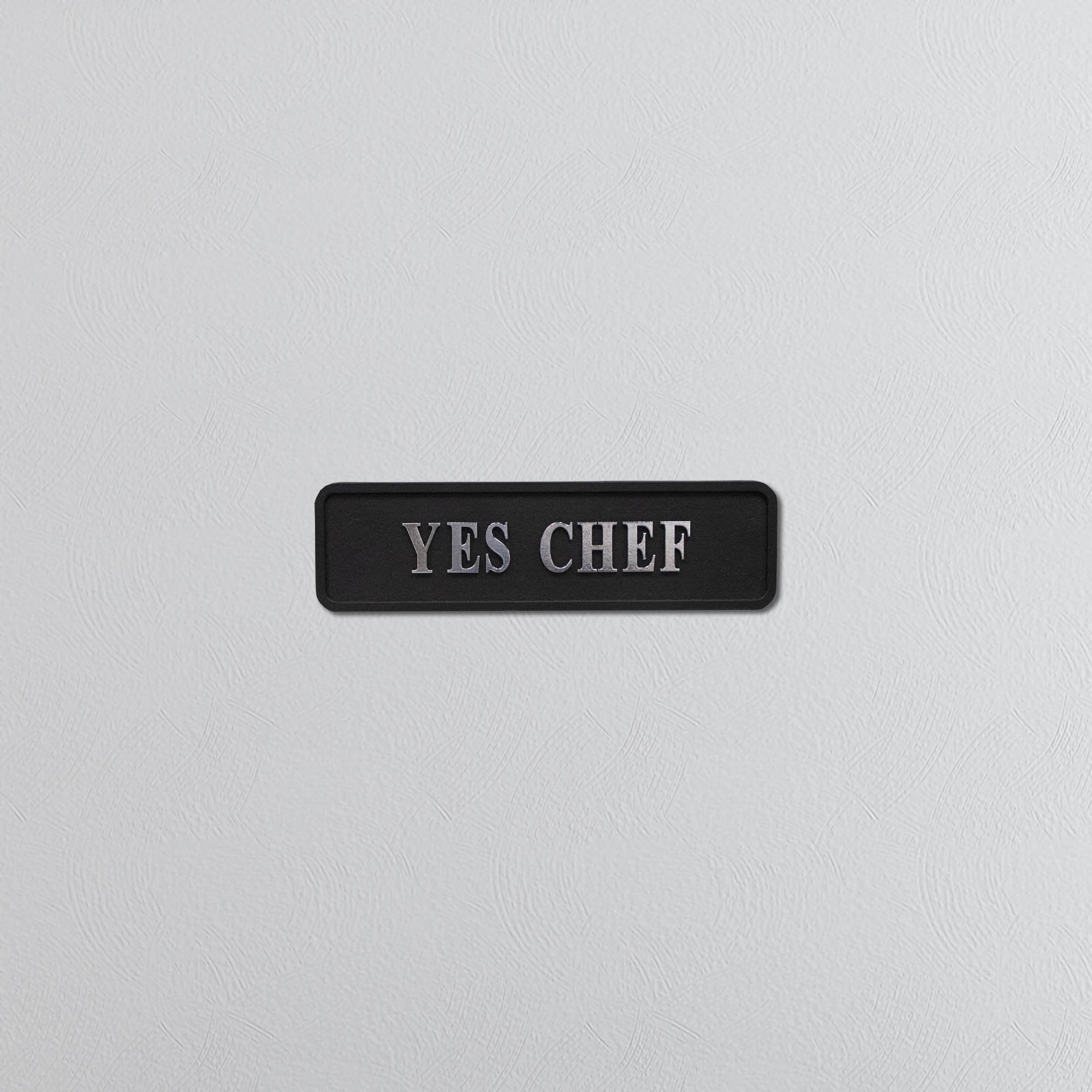 Black decorative sign with silver text YES CHEF