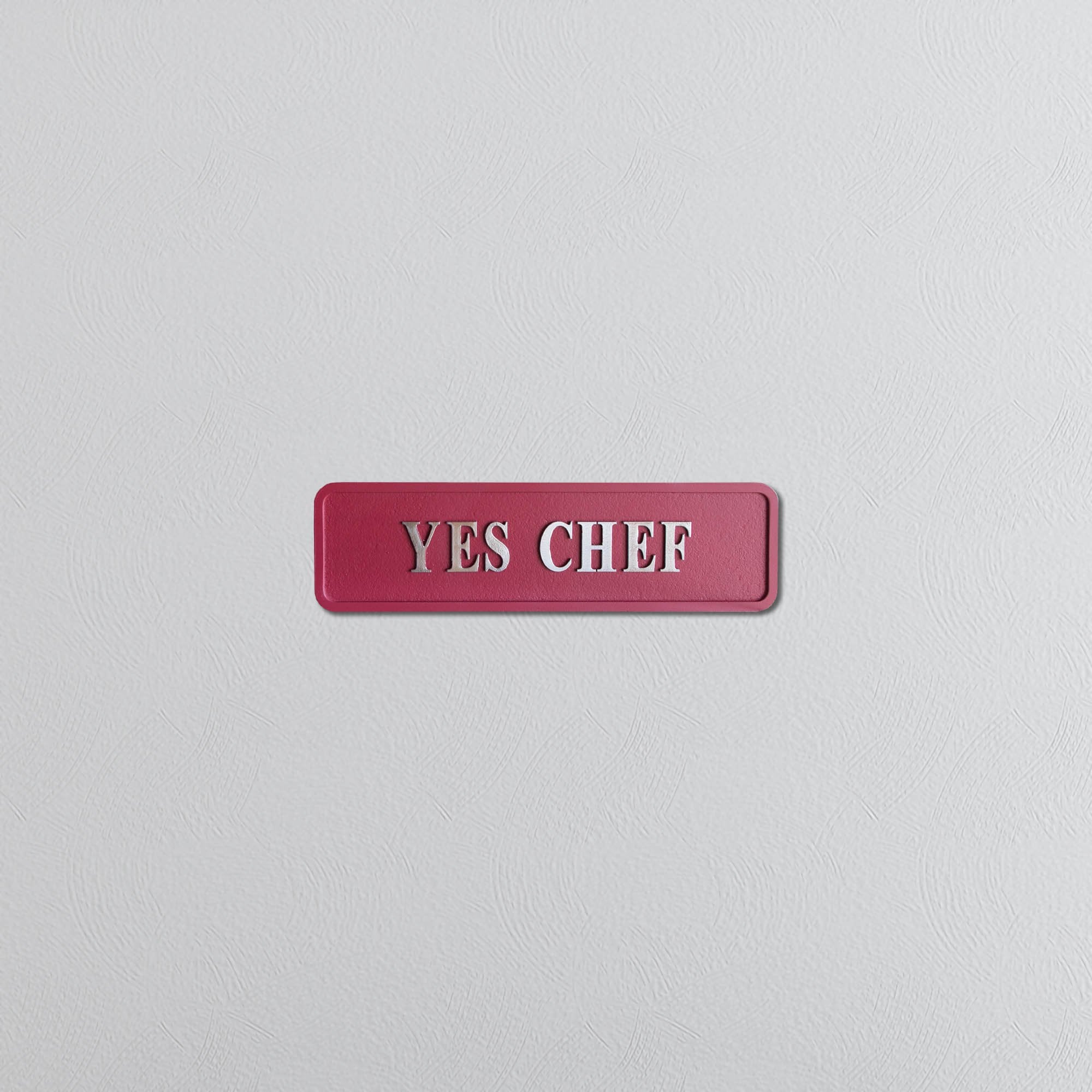 Decorative red sign with silver text reading YES CHEF