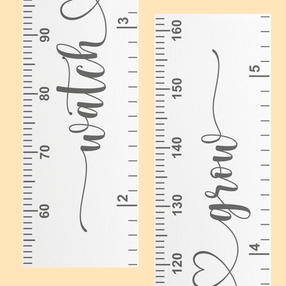 Close up of a white growth chart with cursive script printed up the middle saying 'watch me grow' in grey