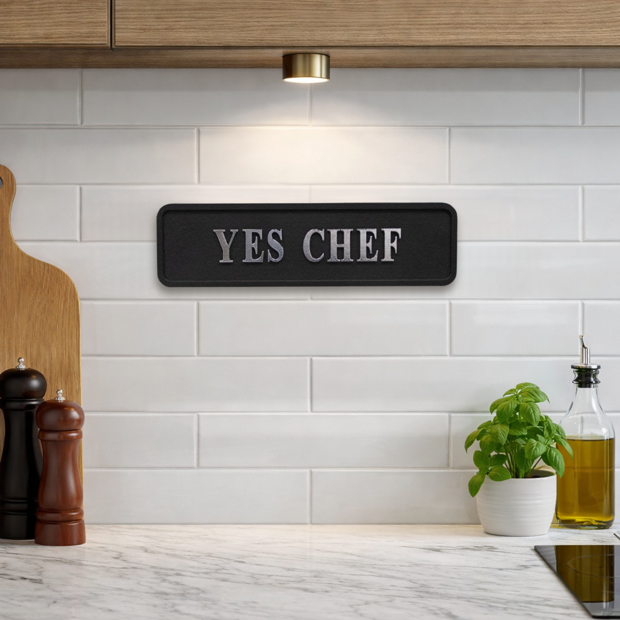 Black decorative sign with silver text YES CHEF in a kitchen