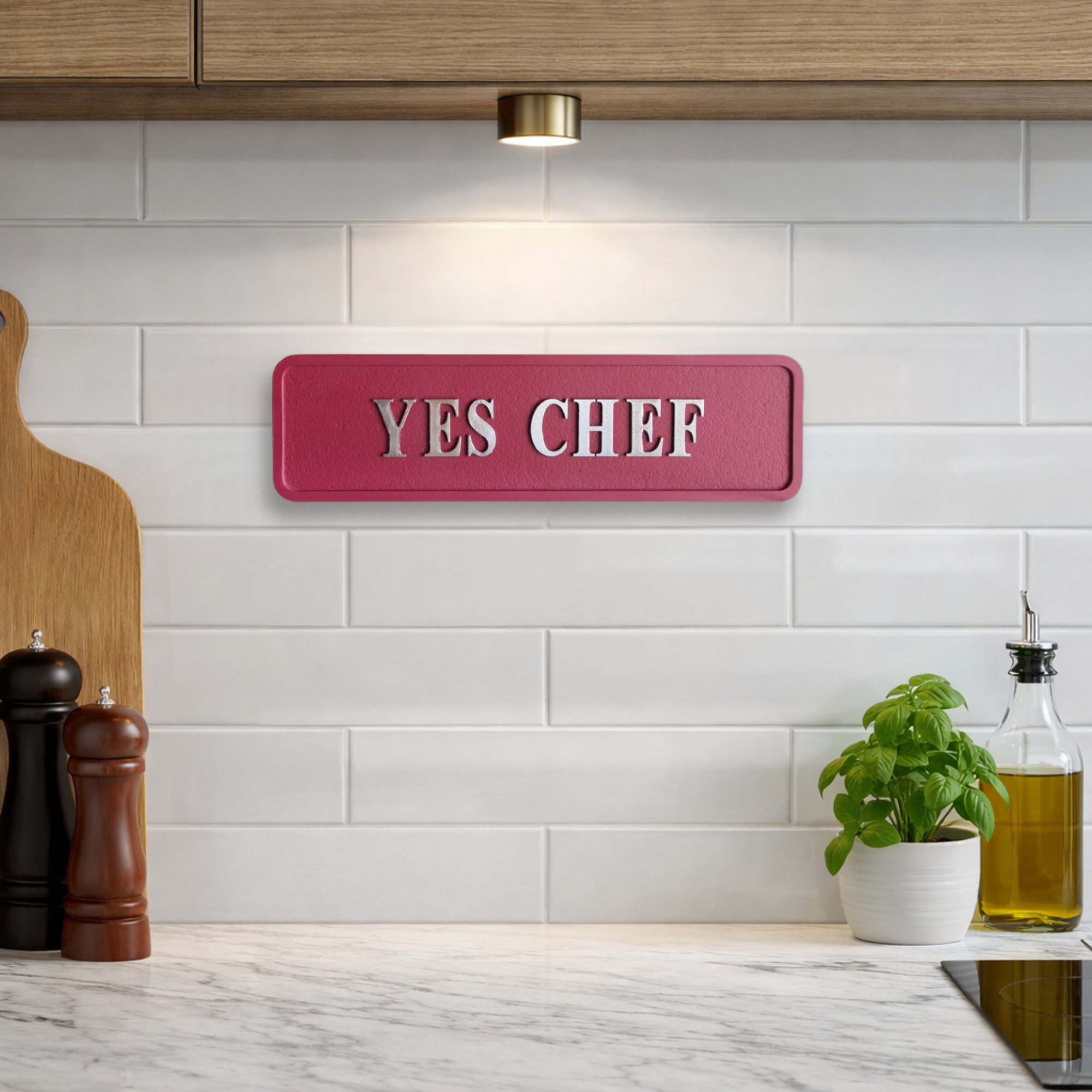 Decorative red sign with silver text reading YES CHEF in a bright kitchen