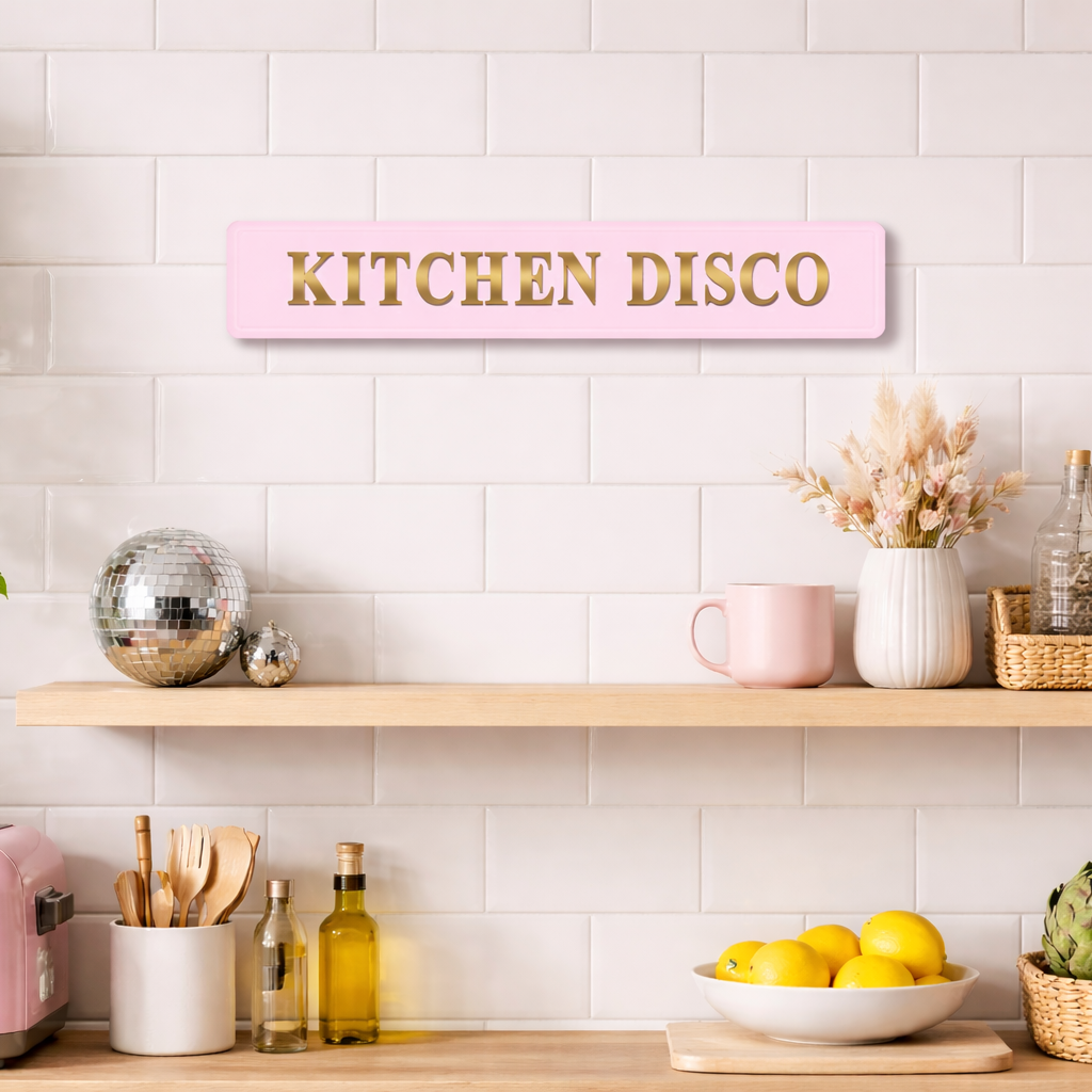 Pink and gold foiled street sign with 'Kitchen disco' wording in a girly pink kitchen